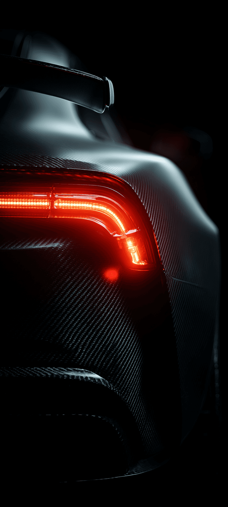 Close-up of a car's rear light glowing red against a dark background, showcasing sleek design and modern automotive aesthetics.